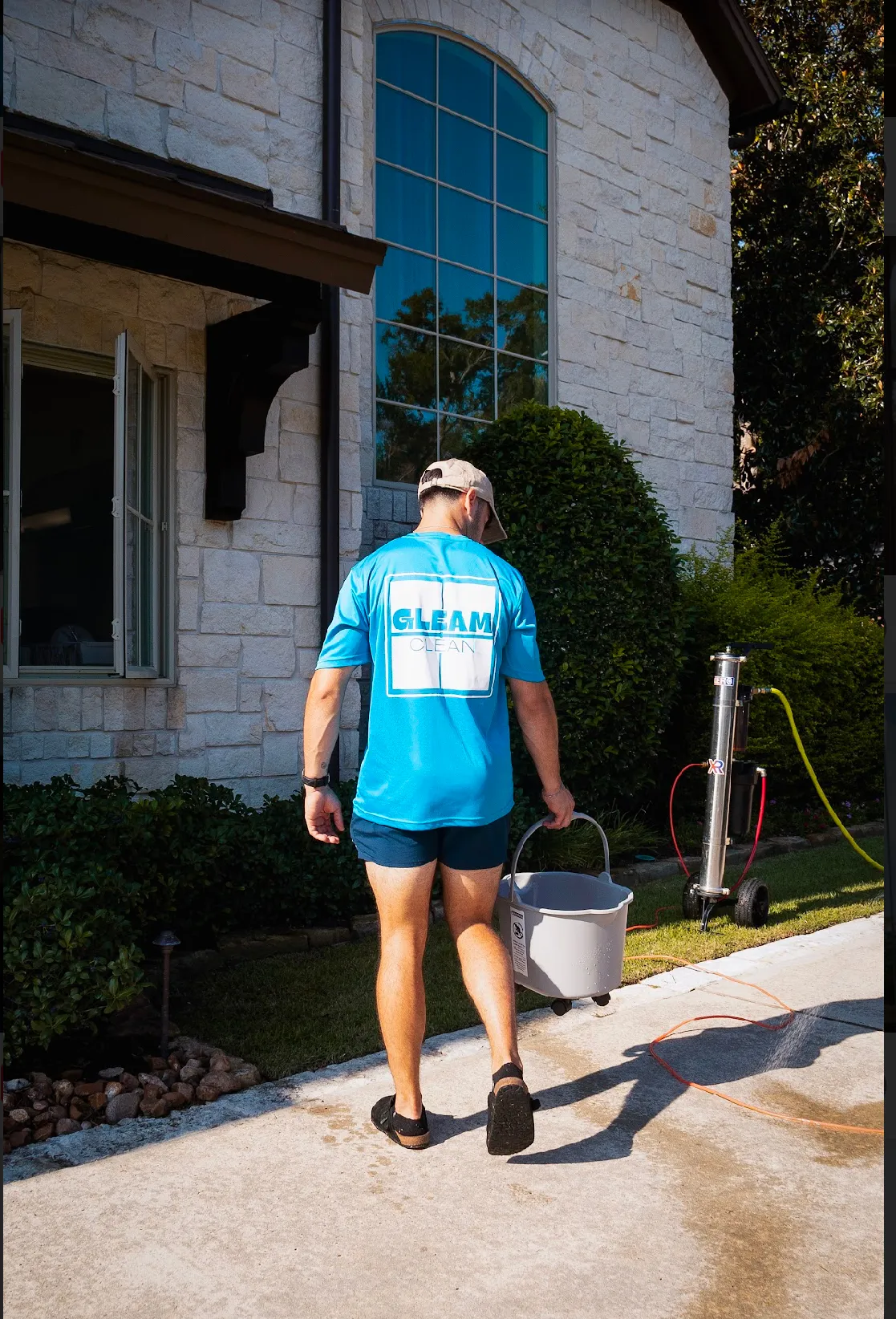 Gleam Clean crew outside a residential brick home with windows and exterior surfaces