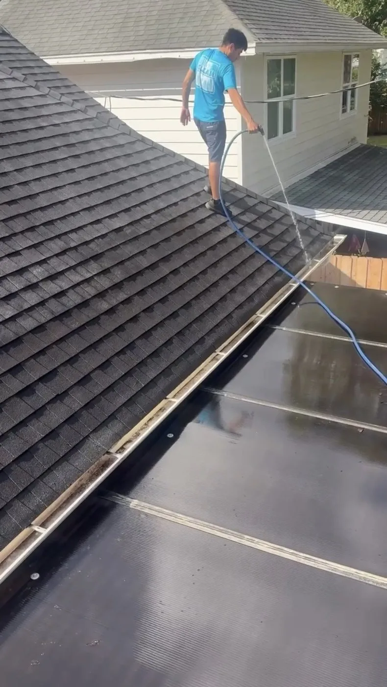 Gutter cleaning at a tree-heavy Houston home roofline.