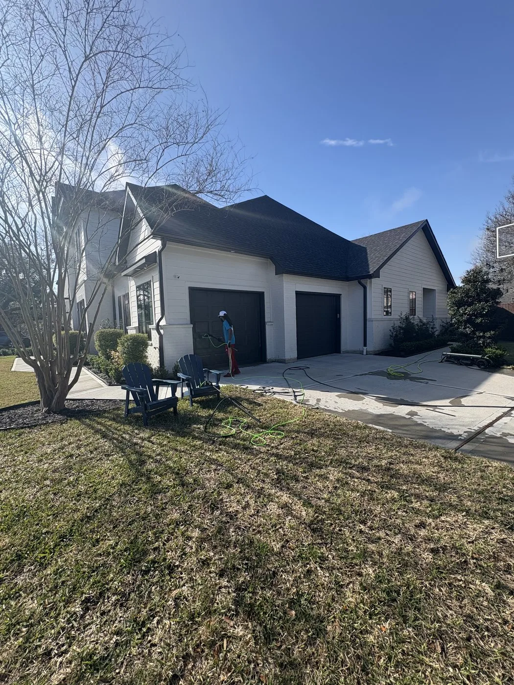 Modern Houston home exterior with cleaning equipment staged for service.